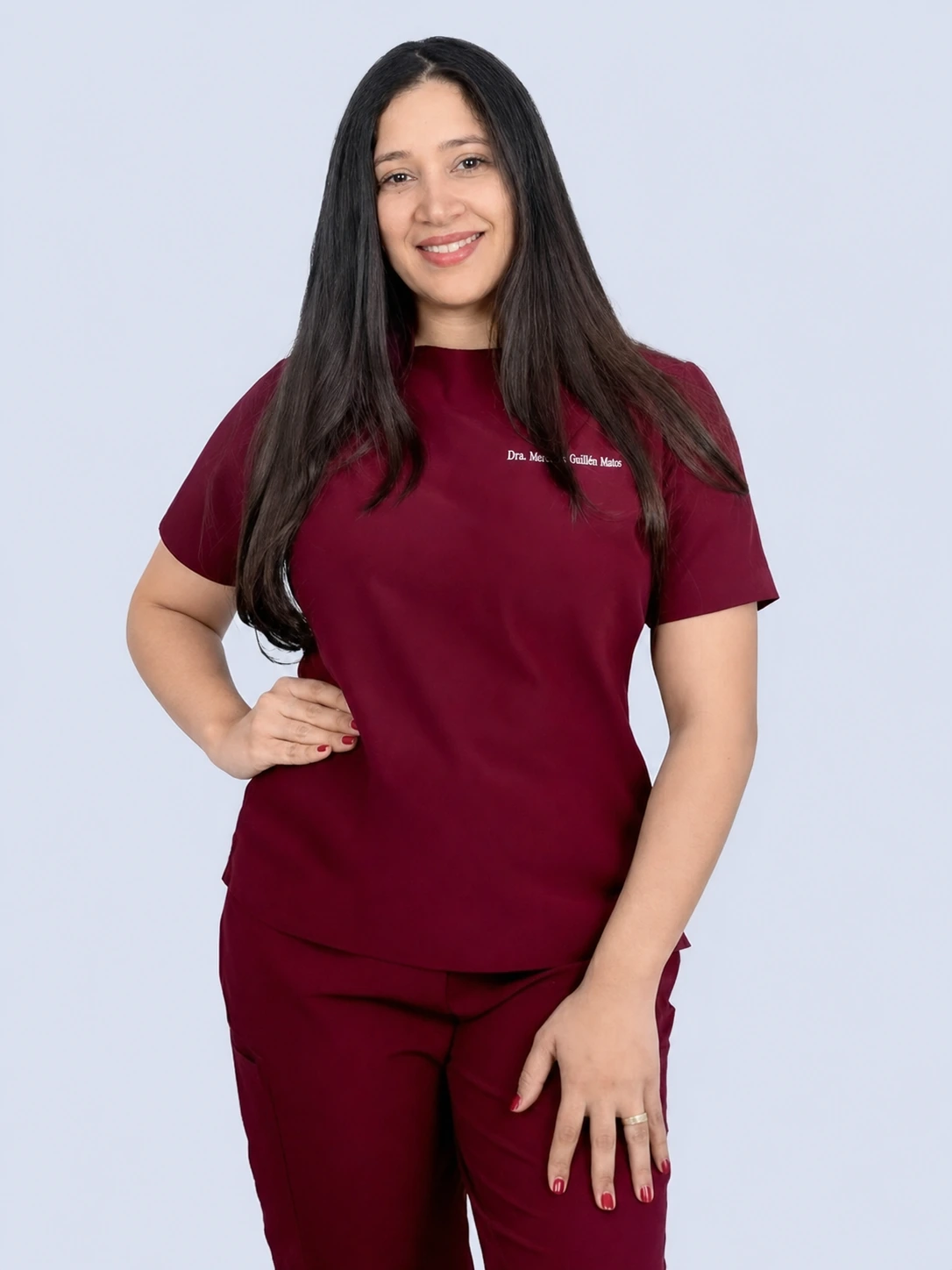 Retrato profesional de la Dra. Mercedes Guillén Matos con uniforme médico color vino